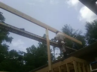 Carpenter setting a ridge beam over a new addition frame — Ice Dam Removal by Roofing Brothers in Humphrey