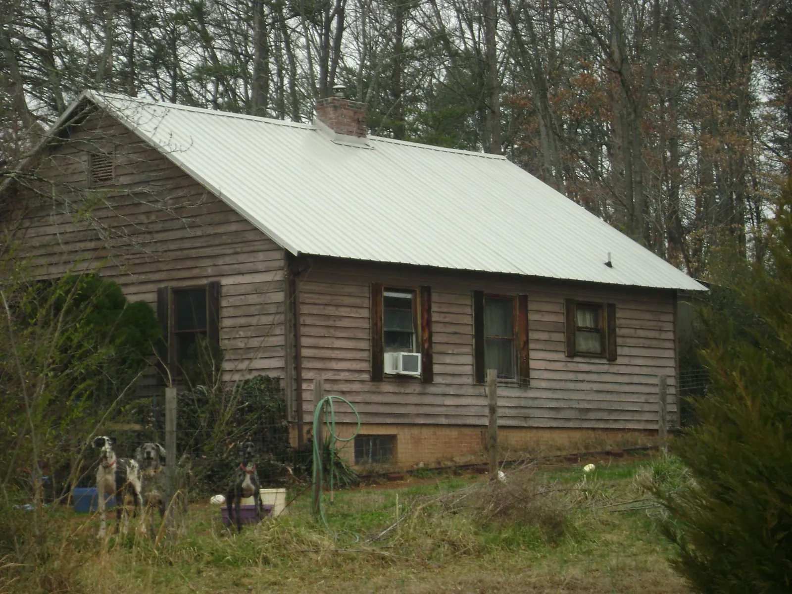 White metal roof on an old wood sided farmhouse, from a Metal Roof Installation job in Humphrey
